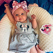Bayleigh joined the competition — help win amazing prizes! baby, blue, celebration, child, cute, dress, grey, headband, indoor, infant, lying_down, mickey_mouse, milestone_card, minnie_mouse, person, pillow, pink, raised_arm, smiling, soft_texture