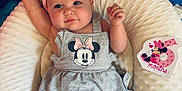 Bayleigh joined the competition — help win amazing prizes! baby, blue, celebration, child, cute, dress, grey, headband, indoor, infant, lying_down, mickey_mouse, milestone_card, minnie_mouse, person, pillow, pink, raised_arm, smiling, soft_texture