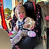 Bayleigh is registered to the contest to win money with this photo: baby, child, toddler, car, car_seat, pacifier, safety_harness, sitting, blonde_hair, ponytail, hair_bow, pink_clothing, striped_tights, toy, plush_toy, minnie_mouse, vehicle_interior, open_door, sunlight, outdoor_background