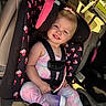 bow, car, car_seat, child, disney, girl, harness, minnie_mouse, passenger, pastel, pink, portrait, road_trip, seatbelt, sippy_cup, smiling, sunlight, toddler, toy, vehicle_interior