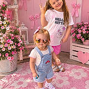 Bayleigh joined the competition — help win amazing prizes! children, girls, toddler, smiling, portrait, outdoor, pink_theme, flowers, flower_pots, bows, hello_kitty, sunglasses, heart_shaped_sunglasses, peace_sign, overalls, shorts, sneakers, rug, garden, playful