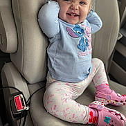 Bayleigh is registered to the contest to win money with this photo: toddler, child, car_seat, smiling, happy, blue_shirt, stitch_character, floral_leggings, pink_crocs, minnie_mouse, car_interior, seatbelt_buckle, cute, casual_clothing, footwear, sitting, portrait, young_child, playful, joyful
