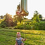 Kensley is registered to the contest to win money with this photo: baby, child, balloon, number_one, grass, outdoor, sunset, nature, greenery, headband, overalls, sitting, curious, sunlight, field, celebration, happy, summer, one_year, portrait