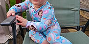 Kensley joined the competition — help win amazing prizes! baby, child, pajamas, smiling, chair, outdoor, grass, wooden_deck, hand, foot, face, blue_eyes, happy, clothing, infant, person, daylight, playful, cute, nature