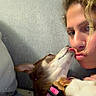 person, dog, small_dog, pet, kissing, affection, cuddling, tongue, face, portrait, indoor, couch, pillow, collar, leash, brown_and_white, blonde_hair, nose_ring, sparkles, selfie