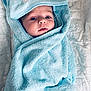 baby, blue_towel, blanket, face, hood, infant, lying_down, person, portrait, quilt, soft, snug, towel, wrapped, cute, child, cozy, baby_face, fabric, bed