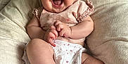 Isabella is registered to the contest to win money with this photo: baby, smiling, infant, child, cute, happy, clothing, pink, white, cushion, indoor, person, face, skin, foot, hand, bed, fabric, relaxed, joy