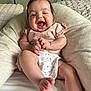 baby, smiling, infant, child, cute, happy, clothing, pink, white, cushion, indoor, person, face, skin, foot, hand, bed, fabric, relaxed, joy
