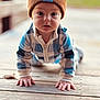 baby, child, crawling, beanie, hat, outdoor, wood, deck, plaid, blue, white, brown, face, hands, clothing, person, portrait, cute, infant, cold_weather