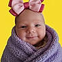 baby, smiling, face, headband, bow, purple_blanket, wrapped, portrait, infant, cute, yellow_background, happy, closeup, soft_texture, child, newborn, warm, cozy, person, head
