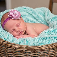 Charlotte joined the competition — help win amazing prizes! baby, newborn, sleeping, headband, flower, blanket, basket, wicker, soft, cozy, infant, cute, peaceful, resting, indoors, child, portrait, skin, pink, turquoise