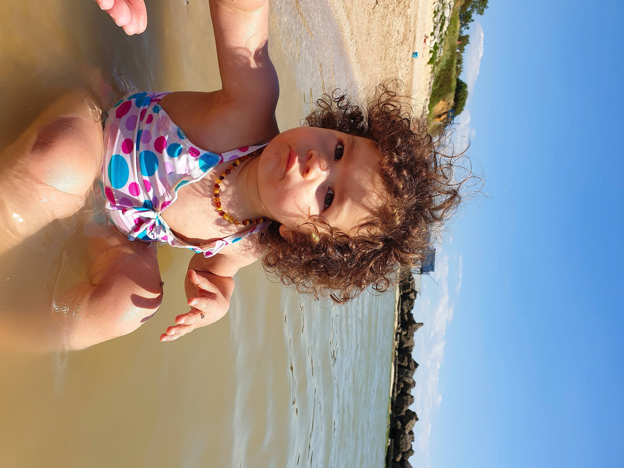 Lilia participe au concours pour gagner de l'argent avec cette photo : arm, beach, blond, child, flash_photography, fun, happy, lake, leisure, people_in_nature, people_on_beach, person, sand, skin, sky, smile, summer, sunlight, swimwear, toddler