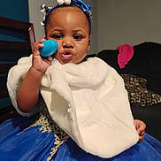Kelaia joined the competition — help win amazing prizes! toddler, child, dress, blue_dress, fur_shawl, headband, blue_headband, indoor, living_room, sofa, chair, pillow, person, cute, playful, face, hand, toy, smile, portrait