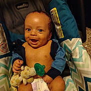 Quincy is registered to the contest to win money with this photo: baby, child, infant, smiling, happy, portrait, car_seat, sitting, pacifier, stuffed_animal, giraffe_toy, diaper, blue_clothing, striped_fabric, indoor, close_up, face, baby_carrier, safety_label, photography