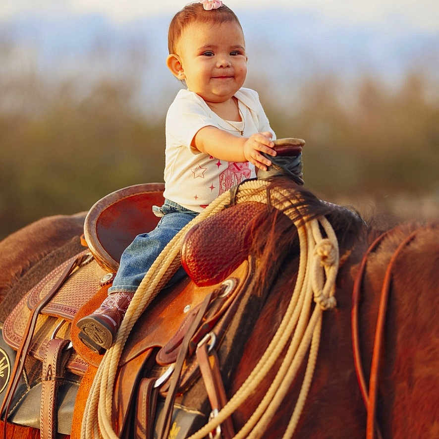 Everly is registered to the contest to win money with this photo: accessories, animal, baby, clothing, colthorse, equestrian, face, hat, head, helmet, horse, pants, person, photography, portrait, rodeo, rope, saddle, strap, sunhat