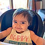 Octavia is registered to the contest to win money with this photo: baby, child, smiling, high_chair, bib, food, indoor, happy, face, portrait, cute, infant, person, table, meal, messy, dining, young_child, closeup, expression