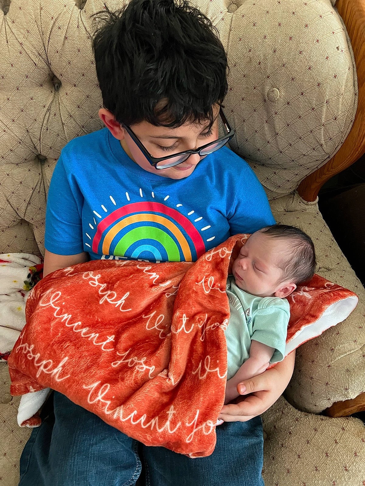 Camdyn joined the competition — help win amazing prizes! arm, baby, baby_toddler_clothing, child, clothing, comfort, event, face, facial_expression, fun, hairstyle, happy, interaction, linens, pattern, person, red, sitting, t_shirt, textile