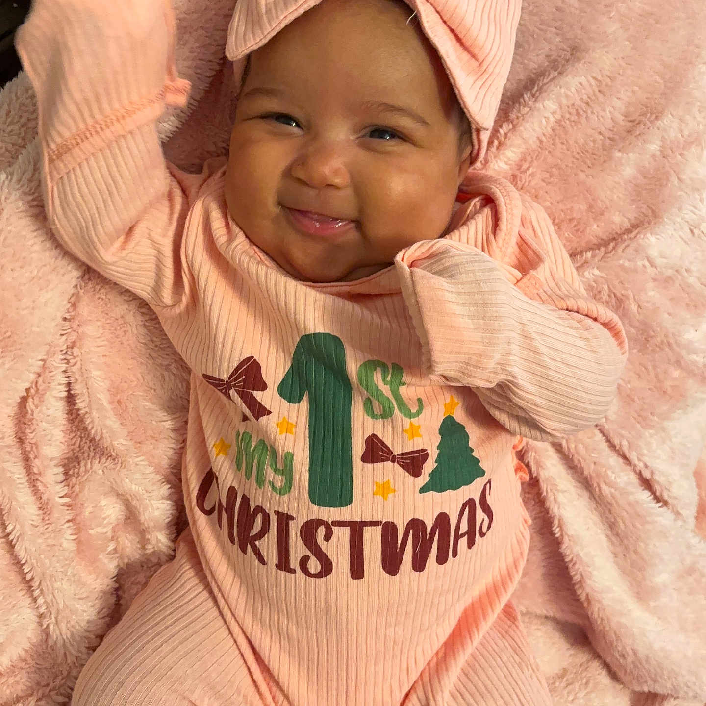 Amairra is registered to the contest to win money with this photo: baby, blanket, celebration, child, christmas, closeup, cozy, cute, festive, happy, headband, holiday, indoors, infant, newborn, pink_onesie, portrait, smiling, soft_texture, warm_colors