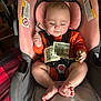 Malayha is registered to the contest to win money with this photo: baby, infant, car_seat, money, dollar_bills, orange_clothing, feet, happy, smiling, indoor, child, seat_belt, pink_cushion, toy, playful, cute, face, hand, legs, foot