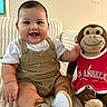 Zayden joined the competition — help win amazing prizes! baby, child, infant, smiling, happy, portrait, sitting, plush_toy, monkey, stuffed_animal, indoor, blanket, couch, sports_jersey, red_clothing, overalls, shoes, family, cozy, photography