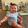 Zayden joined the competition — help win amazing prizes! baby, child, sitting, smiling, portrait, indoors, playroom, carpet, toys, stuffed_animal, activity_center, romper, blue_clothing, barefoot, happy, face, infant, home, floor, daylight