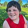 blue_sky, casual_clothing, child, daytime, face, freckles, grass, happy, leisure, nature, outdoor, park, person, portrait, red_shirt, short_hair, smiling, summer, sunlight, tree