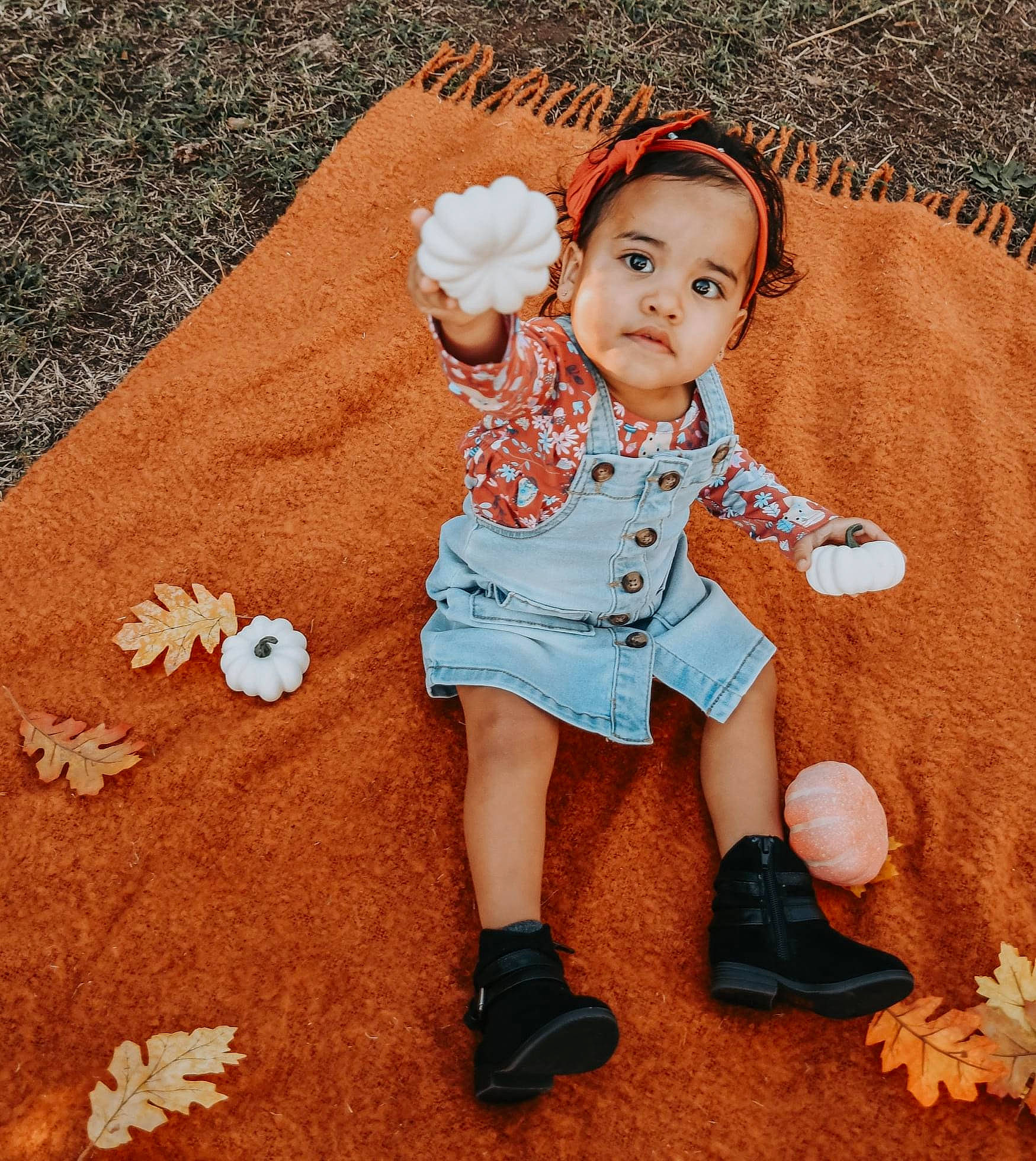 Malayah is registered to the contest to win money with this photo: baby, baby_toddler_clothing, brown_hair, face, fawn, finger, flooring, footwear, grass, happy, head, human_leg, leg, mammal, pattern, person, sitting, sleeve, sock, thumb