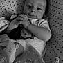 Gaspard participe au concours pour gagner de l'argent avec cette photo : baby, infant, blanket, stars, cushion, pattern, face, hands, clothing, comfort, cute, lying_down, portrait, monochrome, child, indoors, soft, animal_print, pacifier, resting