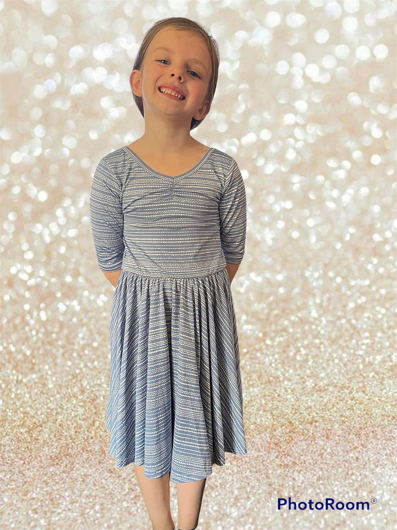 Tessa is registered to the contest to win money with this photo: baby_toddler_clothing, clothing, day_dress, dress, fashion_design, grey, happy, joint, joy, neck, one_piece_garment, outerwear, pattern, person, shoulder, sleeve, smile, street_fashion, summer, toddler