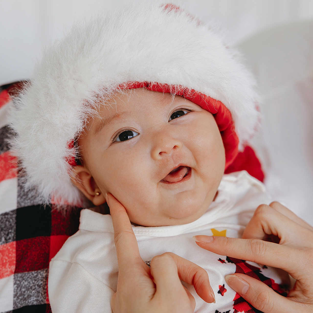 Arlina is registered to the contest to win money with this photo: baby, celebration, child, christmas, cozy, cute, face, festive, fingers, hands, happy, holiday, infant, plaid_blanket, portrait, santa_hat, skin, smile, warm, white_clothing