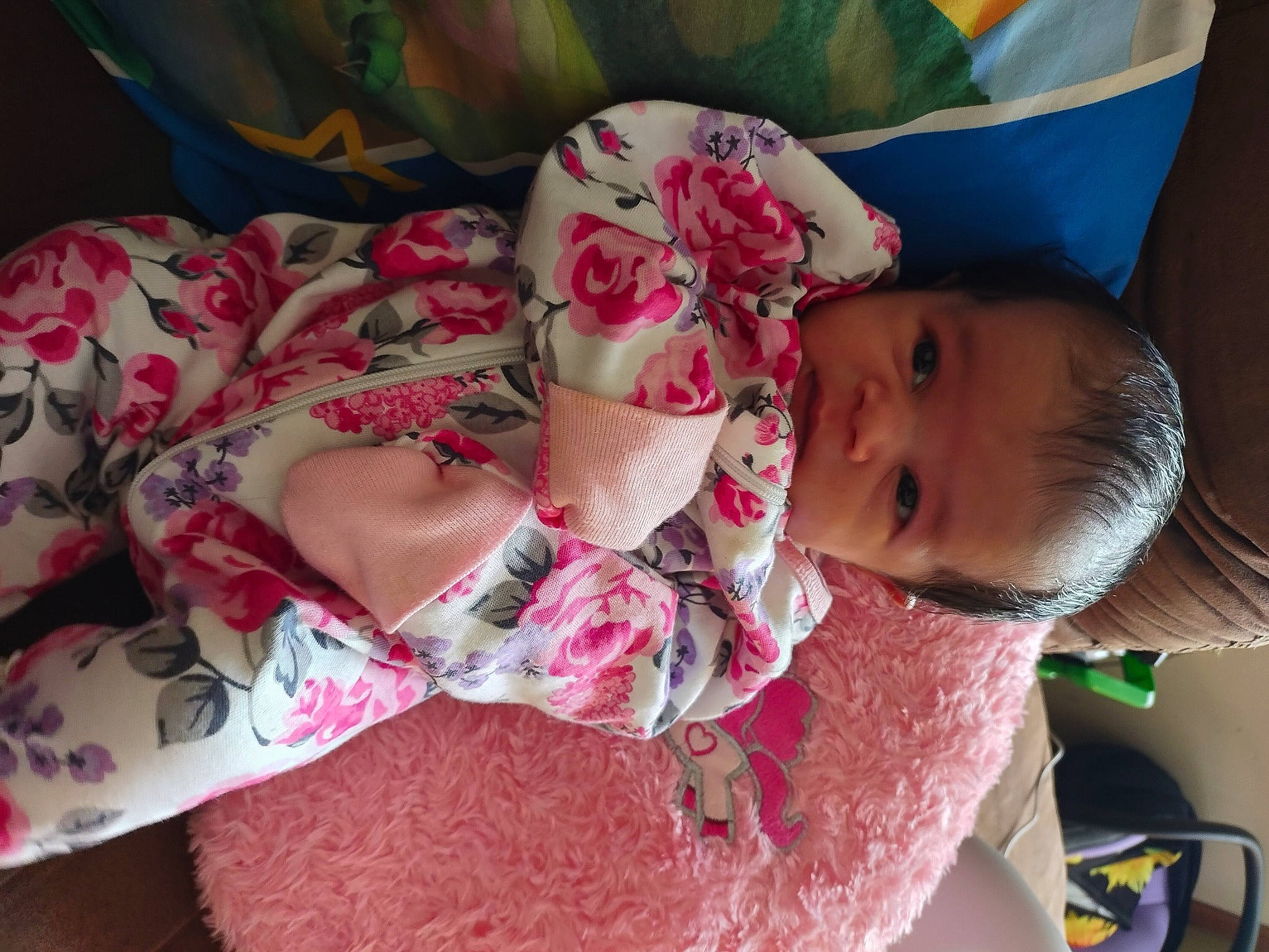 Ari is registered to the contest to win money with this photo: abdomen, baby, baby_products, baby_toddler_clothing, bedding, bedtime, cheek, child, comfort, facial_expression, happy, human_leg, linens, magenta, pattern, person, pink, room, skin, textile