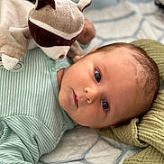 Léandre participe au concours pour gagner de l'argent avec cette photo : baby, infant, plush_toy, raccoon, onesie, striped_clothing, blue_eyes, blanket, quilt, soft_toy, lying_down, close_up, child, cute, indoor, portrait, baby_girl, baby_boy, cozy, warm