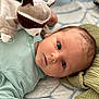 baby, infant, plush_toy, raccoon, onesie, striped_clothing, blue_eyes, blanket, quilt, soft_toy, lying_down, close_up, child, cute, indoor, portrait, baby_girl, baby_boy, cozy, warm