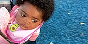 Amiri joined the competition — help win amazing prizes! child, toddler, baby, swing, playground, pink_bow, pink_bib, curly_hair, outdoor, seat, rope, looking_sideways, clothing, person, cute, young_child, expression, infant, seat_belt, play_area