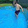 Memphis is registered to the contest to win money with this photo: child, boy, pool, inflatable_pool, water, barefoot, shorts, blue, outdoor, grass, greenery, summer, playing, backyard, nature, toy, toddler, person, casual, daylight