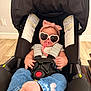 baby, car_seat, sunglasses, pacifier, bow, headband, denim, socks, infant, child, indoor, floor, wooden_floor, clothing, cute, seat_belt, accessory, pink, heart_shaped, casual