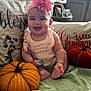 Cataleya is registered to the contest to win money with this photo: baby, infant, headband, flower, smiling, couch, pillow, knitted_pumpkin, orange, yellow, green_blanket, indoors, natural_light, decor, fall_theme, cute, happy, child, soft_texture, home