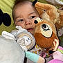 baby, child, plush_toy, stuffed_animal, soft_toy, face, expression, indoors, colorful, cuddly, comfort, cute, young, infant, sleepwear, bed, blanket, closeup, caring, resting