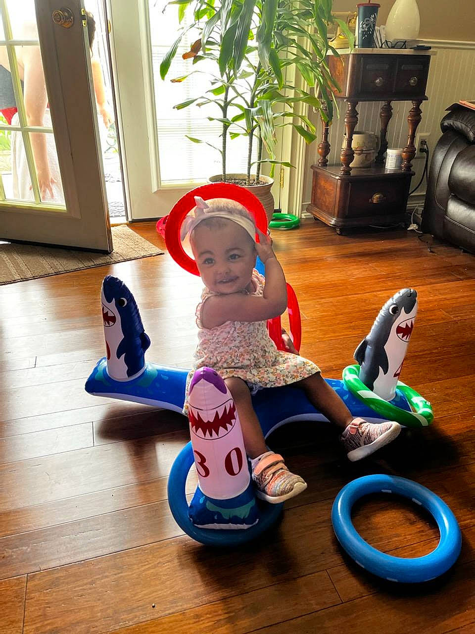 Ariyah is registered to the contest to win money with this photo: automotive_tire, baby, baby_toddler_clothing, child, floor, flooring, fun, hardwood, hat, houseplant, leisure, person, plant, play, recreation, riding_toy, room, sitting, toddler, toy