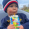 Xavier is registered to the contest to win money with this photo: child, toddler, caprisun, beanie, hat, sweater, drink, juice, outdoor, sky, face, person, hand, straw, cold_weather, curious, cute, portrait, seated, casual_clothing
