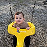 toddler, child, swing, playground, yellow_swing, wood_chips, outdoor, baby, person, play_equipment, daylight, casual_clothing, short_hair, grip, looking_at_camera, play_area, fun, recreation, park, young_child