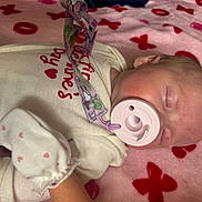 Valerie joined the competition — help win amazing prizes! baby, infant, newborn, sleeping, pacifier, pacifier_clip, blanket, heart_pattern, pink, onesie, mitten, hair, face, cheek, closeup, resting, soft_texture, bed, portrait, baby_clothes