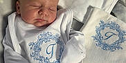 Tommy joined the competition — help win amazing prizes! newborn, baby, sleeping, white_clothing, embroidered, personalized, blanket, soft_light, infant, cute, peaceful, portrait, fabric, bed, cozy, toddler, baby_bib, baby_garment, blue_embroidery, resting