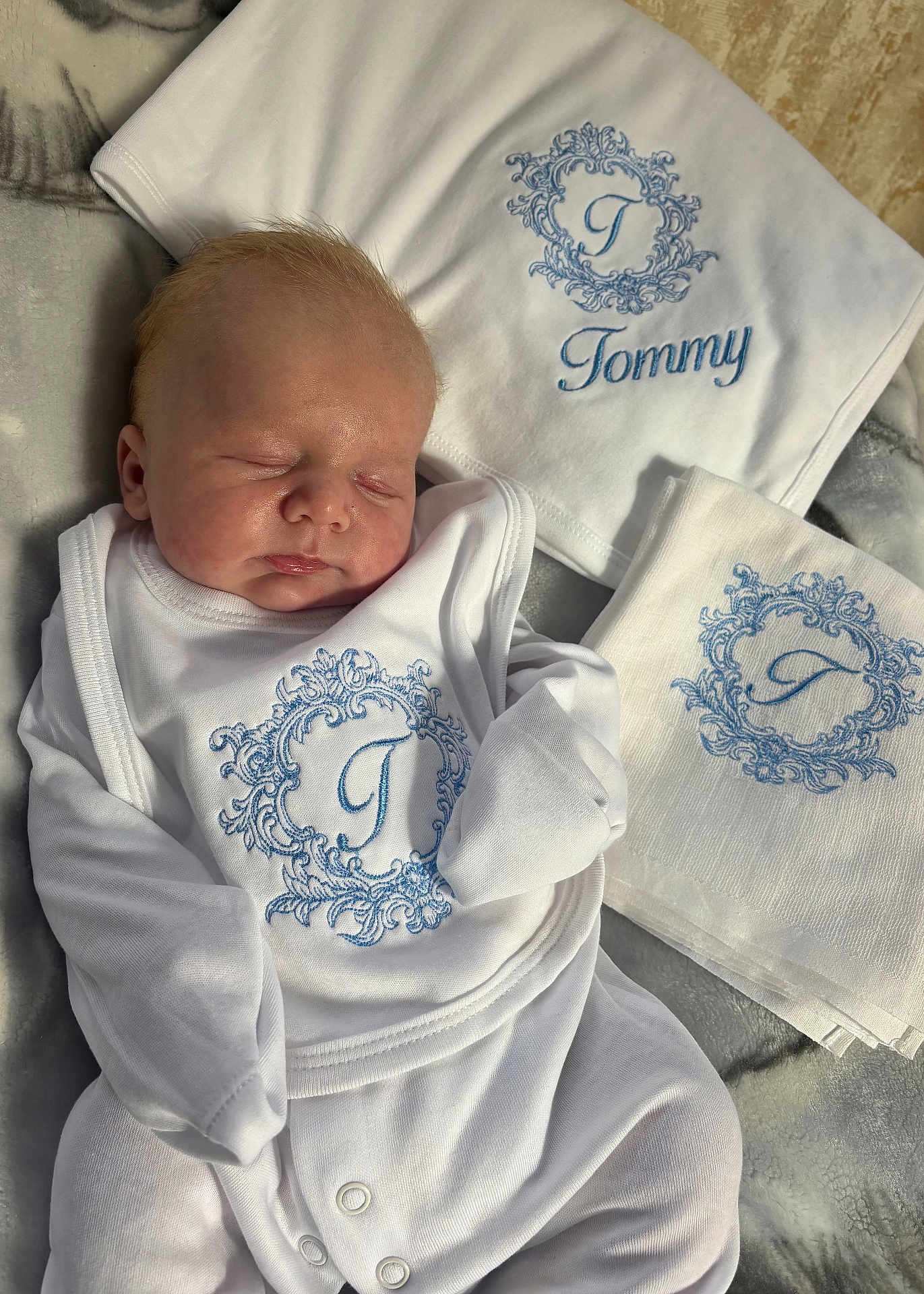 Tommy joined the competition — help win amazing prizes! newborn, baby, sleeping, white_clothing, embroidered, personalized, blanket, soft_light, infant, cute, peaceful, portrait, fabric, bed, cozy, toddler, baby_bib, baby_garment, blue_embroidery, resting