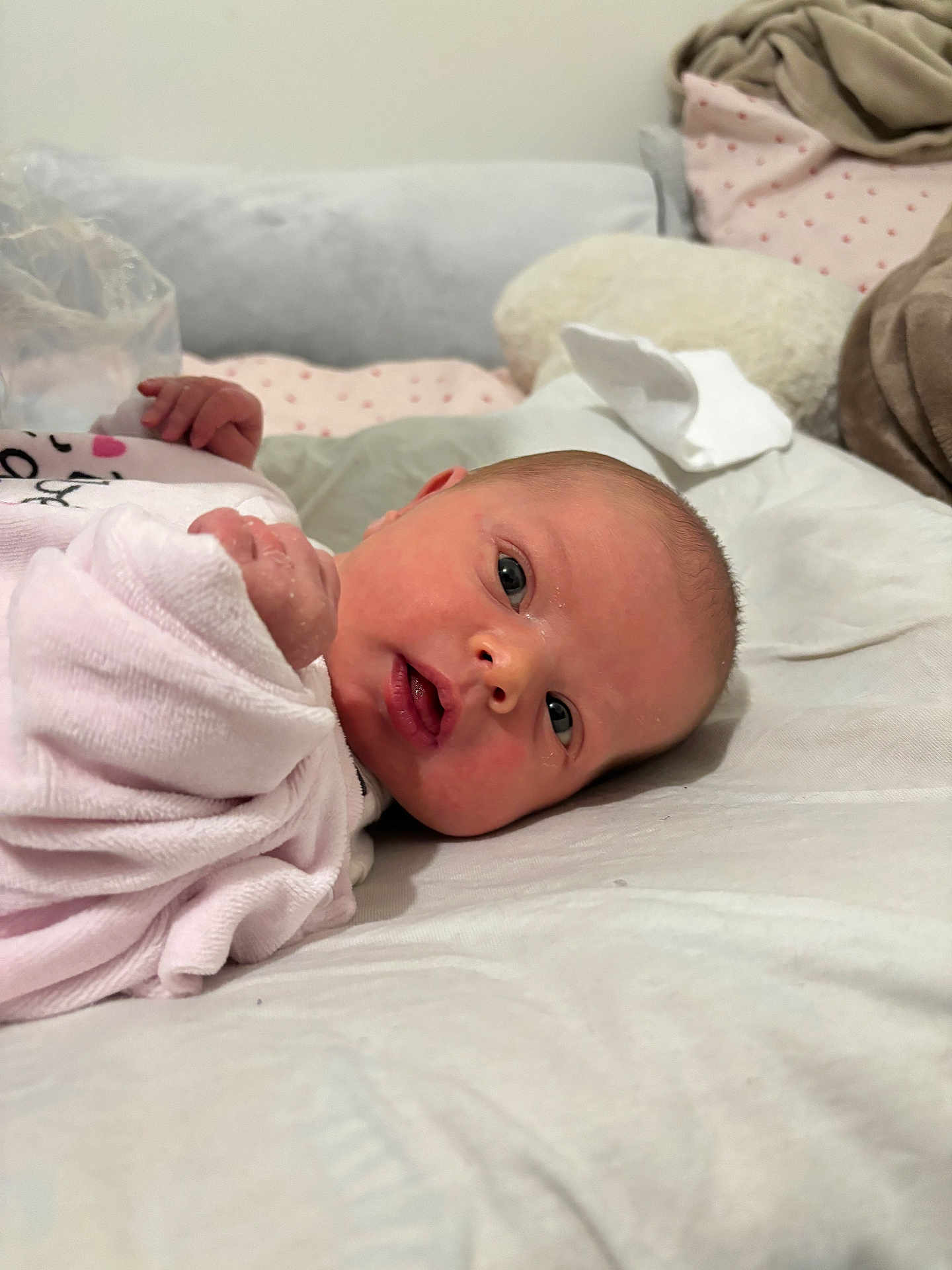 Angel participe au concours pour gagner de l'argent avec cette photo : baby, newborn, infant, person, face, eyes_open, gaze, mouth, hands, blanket, bedding, pillow, swaddle, close_up, lying_down, indoor, cozy, soft_toy, skin, pink