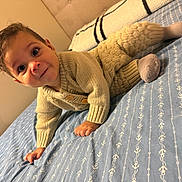 Matteo joined the competition — help win amazing prizes! baby, child, knitted_clothing, crawling, bed, blanket, blue, anchor_pattern, smile, curious, indoors, cozy, cute, infant, person, portrait, soft_lighting, young, socks, warm