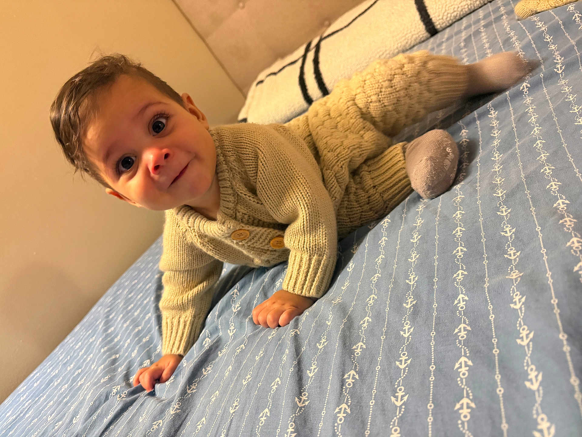 Matteo joined the competition — help win amazing prizes! baby, child, knitted_clothing, crawling, bed, blanket, blue, anchor_pattern, smile, curious, indoors, cozy, cute, infant, person, portrait, soft_lighting, young, socks, warm