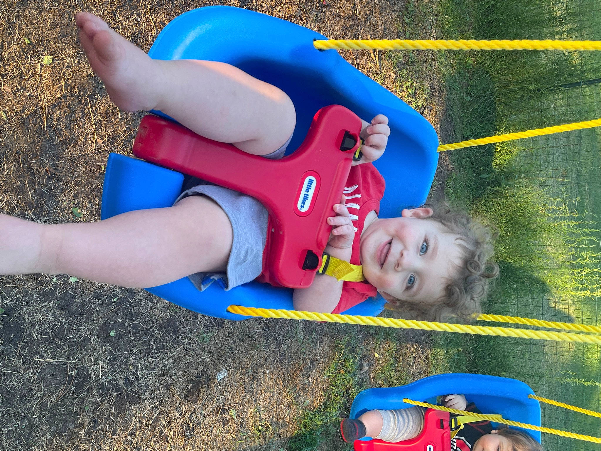 Kashton is registered to the contest to win money with this photo: blue, child, electric_blue, facial_expression, fictional_character, fun, grass, human_leg, joy, knee, leisure, outdoor_play_equipment, people_in_nature, person, play, public_space, recreation, shorts, smile, summer