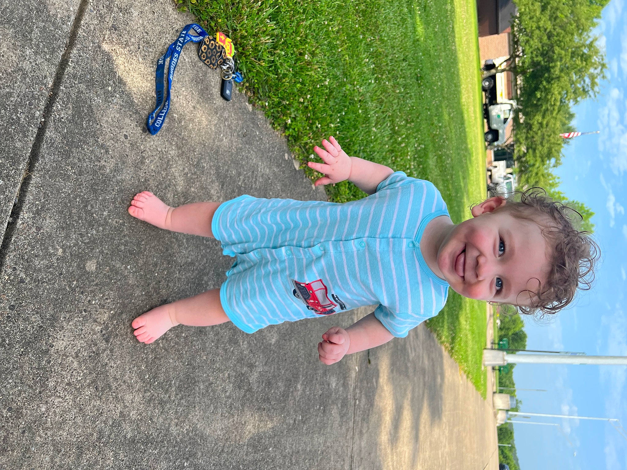Kashton is registered to the contest to win money with this photo: asphalt, baby_toddler_clothing, blue, child, electric_blue, foot, fun, grass, green, happy, joy, leisure, people_in_nature, person, plant, play, recreation, sky, smile, toddler
