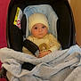baby, blanket, car_seat, child, clothing, cozy, cute, face, hat, indoor, infant, looking_at_camera, newborn, pacifier, person, portrait, seat_belt, seated, soft_texture, warm_lighting